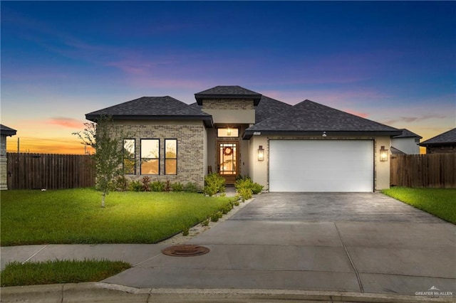 prairie-style house featuring a lawn and a garage