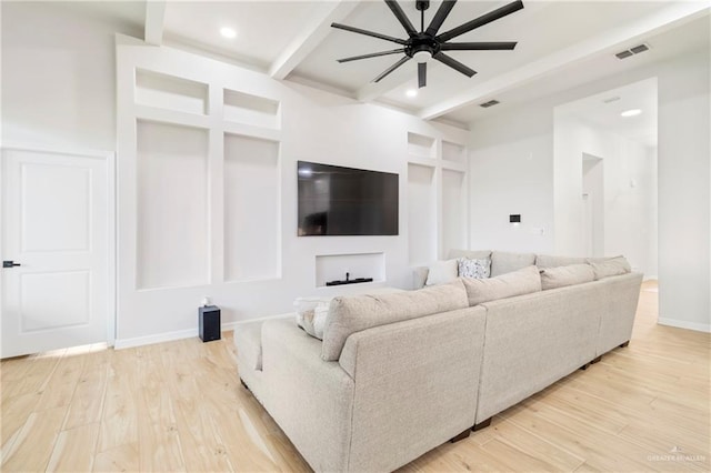 living room featuring beam ceiling, light hardwood / wood-style floors, and ceiling fan