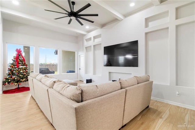 living room featuring beamed ceiling, a towering ceiling, light hardwood / wood-style floors, and ceiling fan