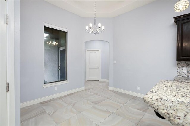 5105 August Ct, Edinburg, TX 78539 - unfurnished dining area with arched walkways, baseboards, a chandelier, and light tile patterned floors