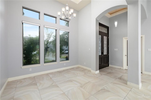 5105 August Ct, Edinburg, TX 78539 - entryway with baseboards, a towering ceiling, arched walkways, and a notable chandelier