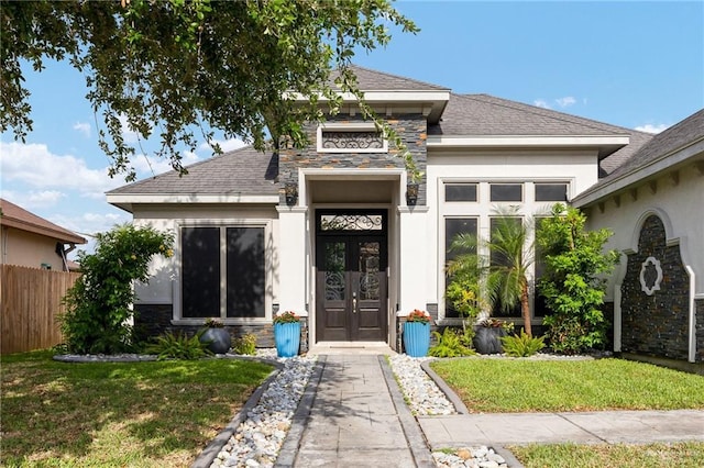 5105 August Ct, Edinburg, TX 78539 - view of front facade with stone siding, french doors, a front yard, and stucco siding
