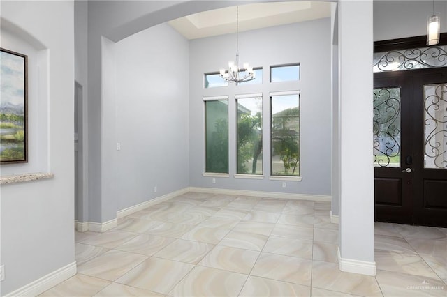 5105 August Ct, Edinburg, TX 78539 - foyer with a towering ceiling, light tile patterned floors, arched walkways, baseboards, and a notable chandelier