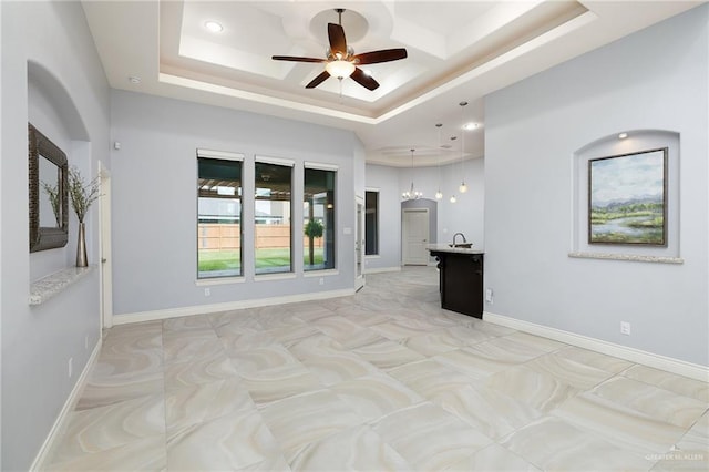 5105 August Ct, Edinburg, TX 78539 - unfurnished living room with a ceiling fan, baseboards, a sink, and a raised ceiling