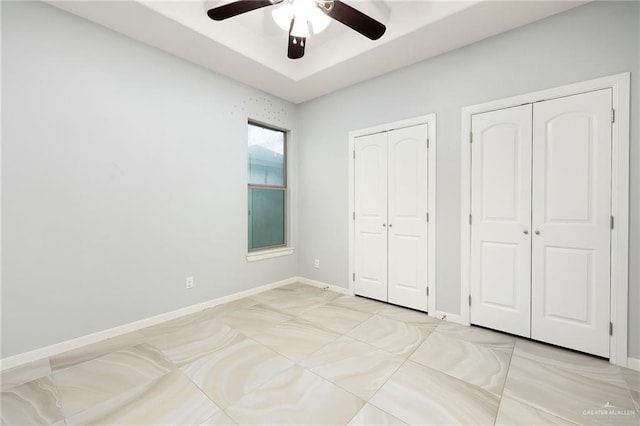 5105 August Ct, Edinburg, TX 78539 - unfurnished bedroom featuring a raised ceiling, multiple closets, a ceiling fan, and baseboards