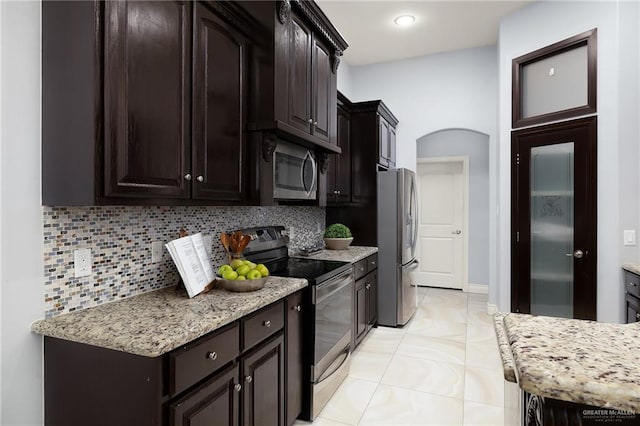 5105 August Ct, Edinburg, TX 78539 - kitchen with dark brown cabinetry, arched walkways, tasteful backsplash, and stainless steel appliances