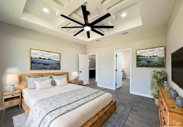 bedroom with a raised ceiling, ceiling fan, and dark wood-type flooring