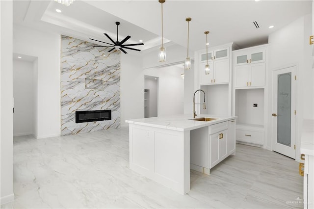 900 N Trinity St, Edinburg, TX 78541 - kitchen featuring light marble finish flooring, recessed lighting, a kitchen island with sink, open floor plan, and white cabinetry