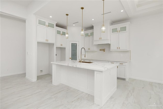 900 N Trinity St, Edinburg, TX 78541 - kitchen with white cabinets, a center island with sink, recessed lighting, light stone countertops, and light marble finish flooring