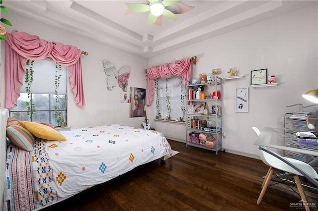 bedroom featuring a tray ceiling, ceiling fan, and dark hardwood / wood-style flooring