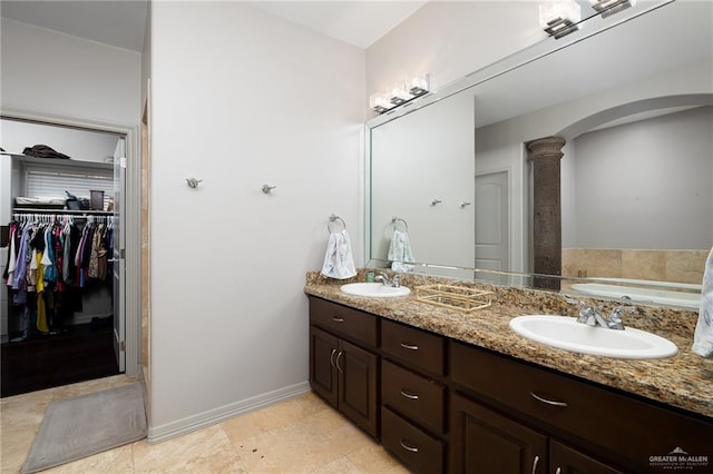 bathroom with ornate columns and vanity