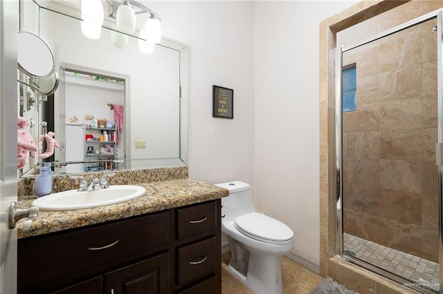 bathroom featuring tile patterned flooring, vanity, toilet, and walk in shower