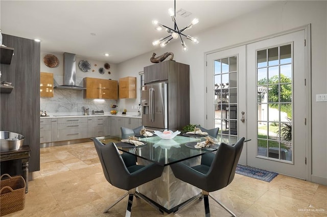 dining room featuring sink, plenty of natural light, french doors, and an inviting chandelier