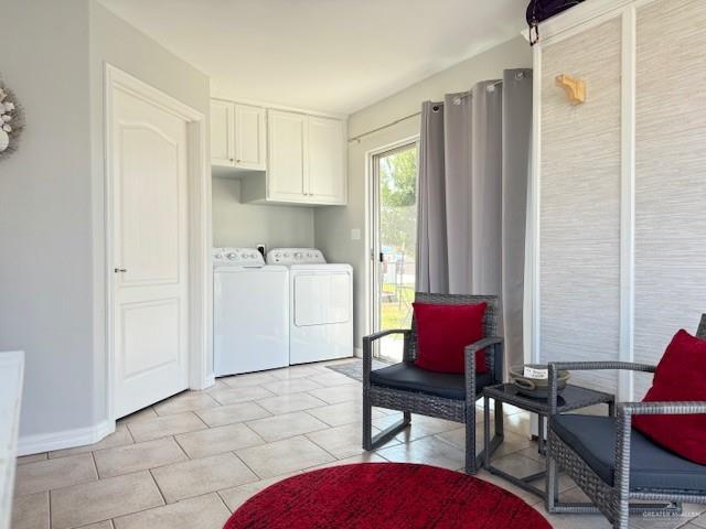 clothes washing area featuring cabinets, light tile patterned floors, and independent washer and dryer