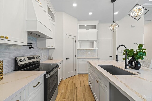 2229 N Ruby St, Edinburg, TX 78541 - kitchen featuring stainless steel range with electric cooktop, a sink, light wood finished floors, white cabinets, and recessed lighting