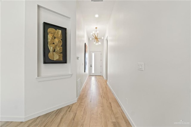 2229 N Ruby St, Edinburg, TX 78541 - hallway featuring light wood-type flooring, a chandelier, and baseboards