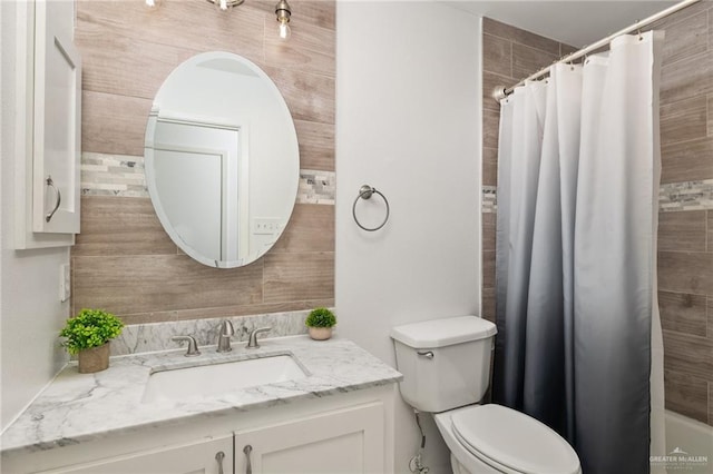 bathroom with toilet, a shower with shower curtain, and vanity