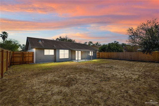 back house at dusk with a yard