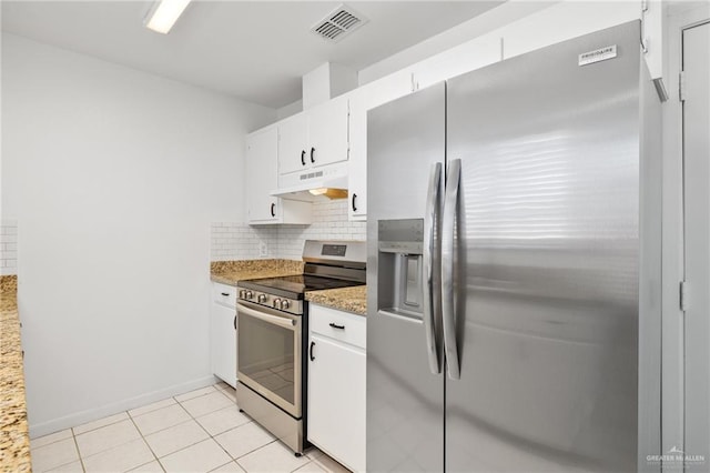 kitchen featuring light stone counters, stainless steel appliances, light tile patterned floors, decorative backsplash, and white cabinets