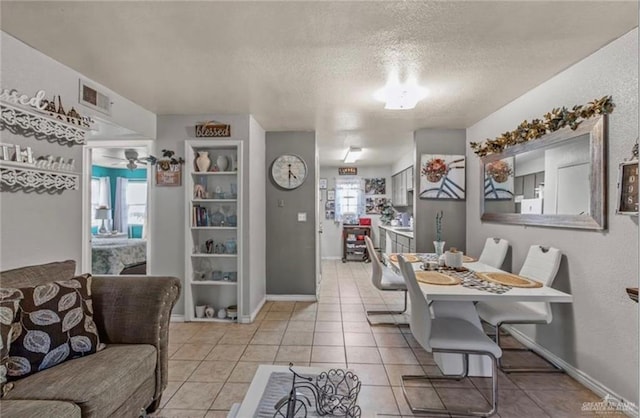 tiled dining room featuring a textured ceiling, plenty of natural light, and ceiling fan