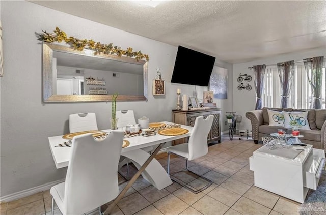 dining area with light tile patterned floors and a textured ceiling