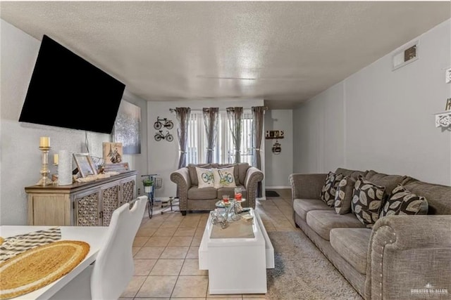 living room featuring a textured ceiling and light tile patterned flooring