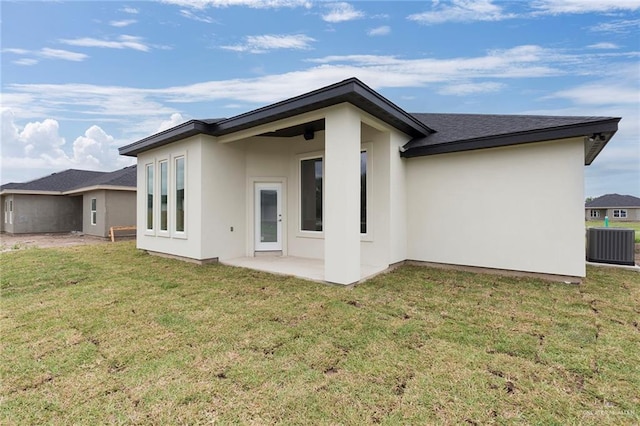 rear view of property with a patio, central AC, and a lawn