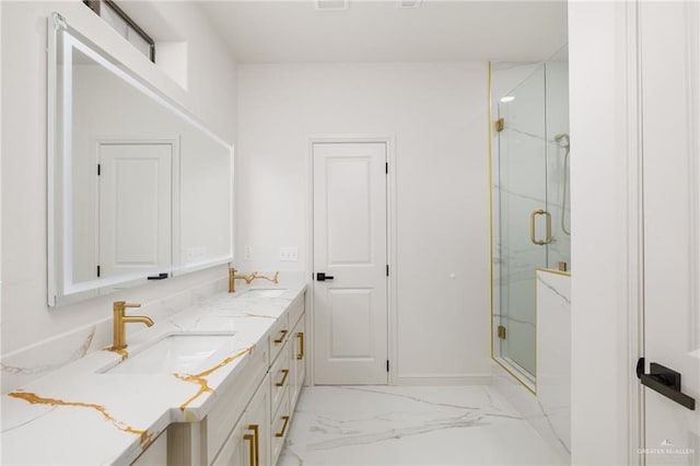 bathroom with marble finish floor, a sink, a marble finish shower, and double vanity