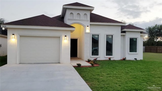 view of front facade featuring a garage, concrete driveway, a front lawn, and stucco siding