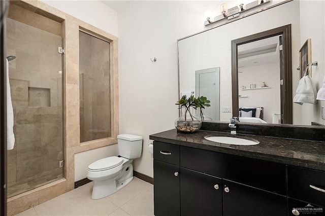 bathroom featuring tile patterned flooring, vanity, a shower with shower door, and toilet