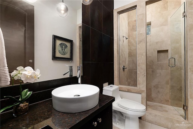 bathroom featuring tile patterned floors, an enclosed shower, sink, tile walls, and toilet