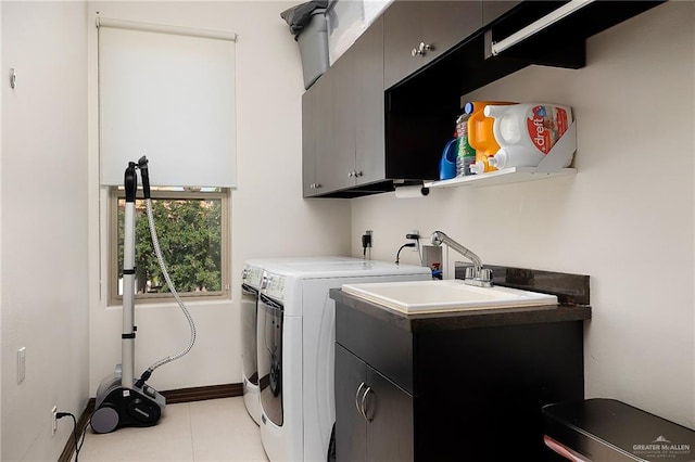 laundry area with cabinets, independent washer and dryer, sink, and light tile patterned floors