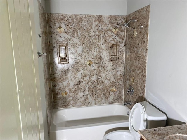 full bathroom featuring tiled shower / bath combo, toilet, and vanity