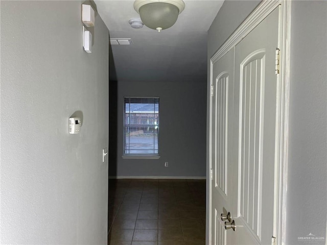 hall featuring dark tile patterned flooring