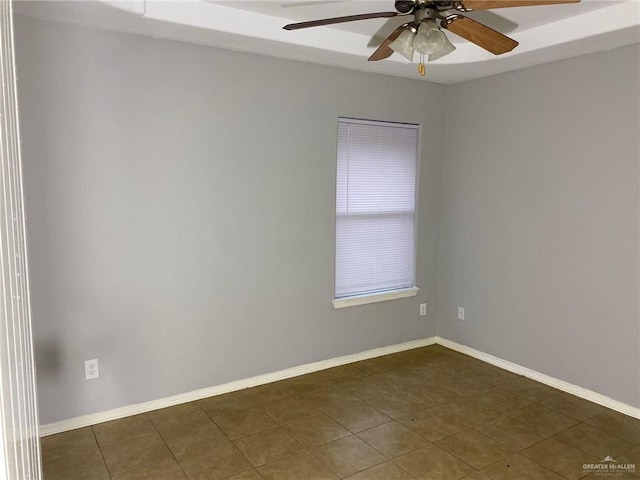 unfurnished room featuring dark tile patterned floors and ceiling fan