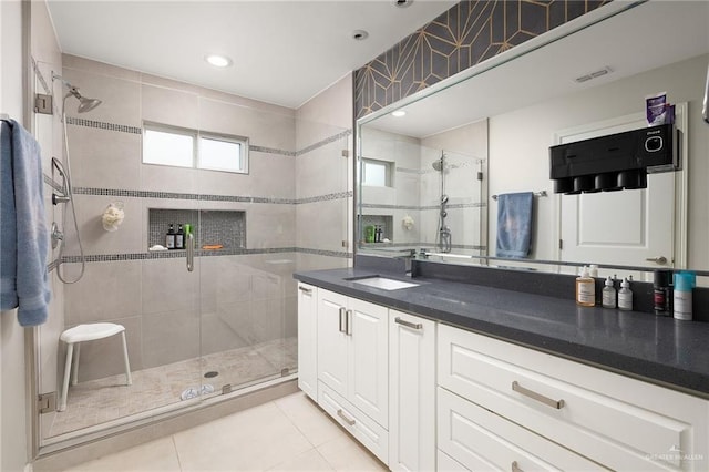 bathroom with tile patterned floors, visible vents, vanity, and a shower stall