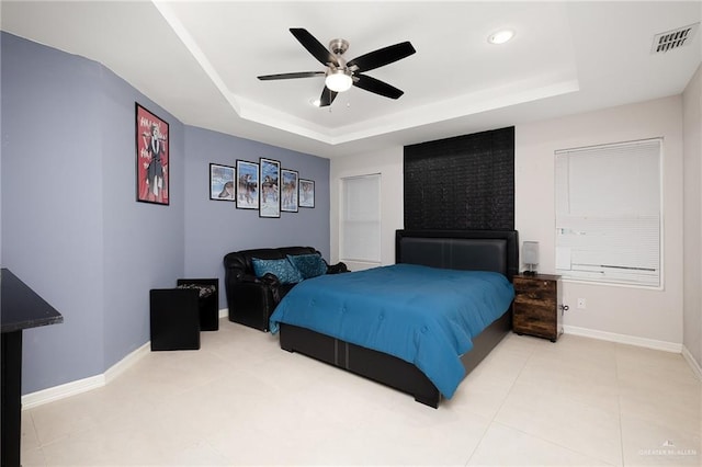 tiled bedroom featuring a raised ceiling, baseboards, and visible vents