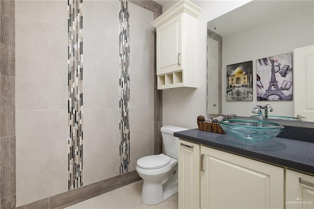 full bath with toilet, vanity, and tile patterned flooring