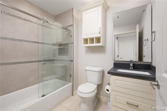 full bathroom with tile patterned floors, toilet, combined bath / shower with glass door, baseboards, and vanity