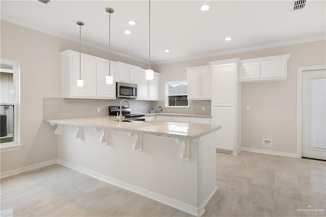 kitchen with stainless steel appliances, backsplash, white cabinetry, a peninsula, and a kitchen bar