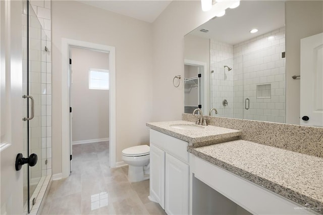 bathroom featuring a stall shower, baseboards, toilet, a spacious closet, and vanity