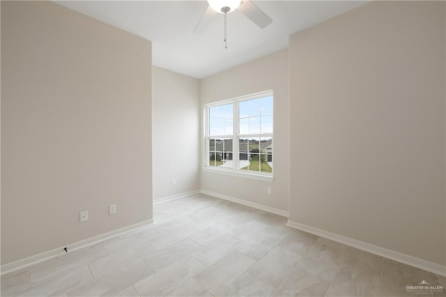 unfurnished room with ceiling fan and baseboards