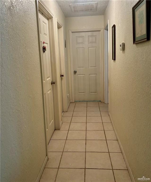 3713 Gonzalez Ln, Mcallen, TX 78504 - hall featuring light tile patterned floors, a textured wall, and a textured ceiling