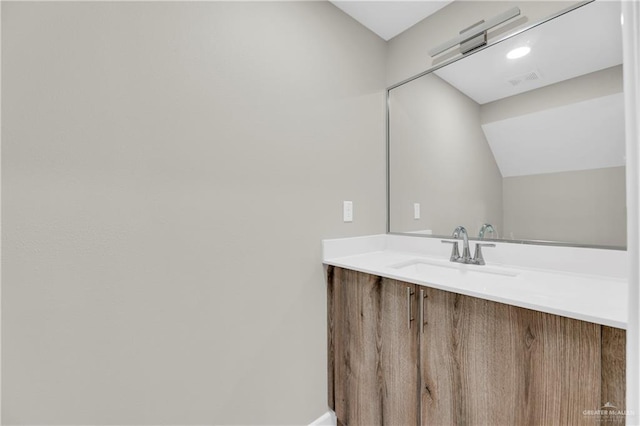 bathroom featuring vanity and lofted ceiling