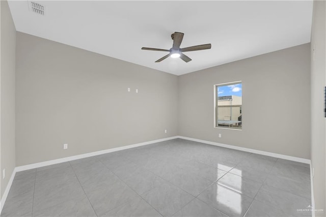 tiled empty room featuring ceiling fan