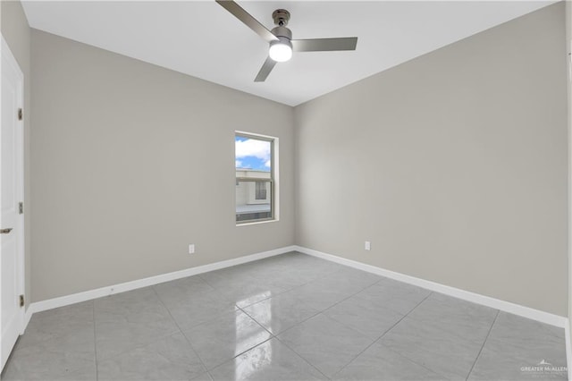 spare room with ceiling fan and light tile patterned floors