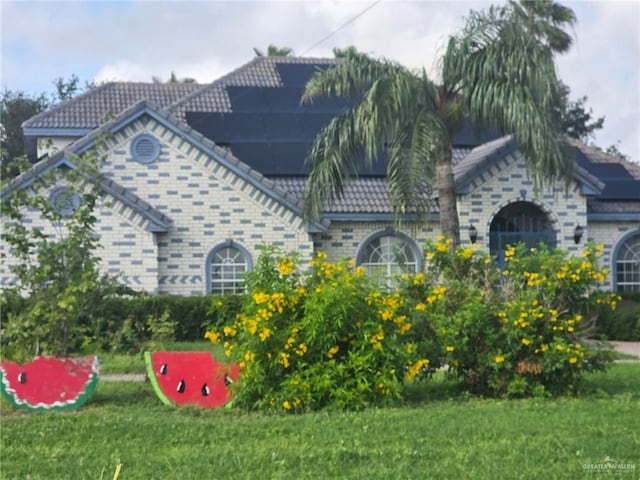 2210 W Monte Cristo Rd W, Edinburg, TX 78541 - view of front of house with roof mounted solar panels and a front lawn