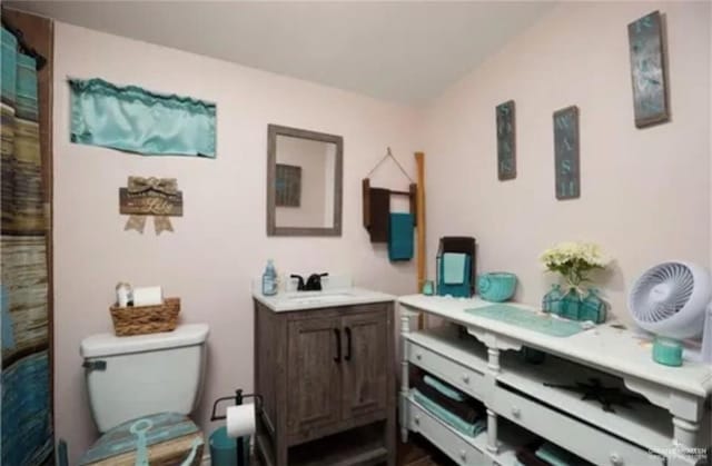 bathroom featuring a shower with curtain, vanity, toilet, and vaulted ceiling