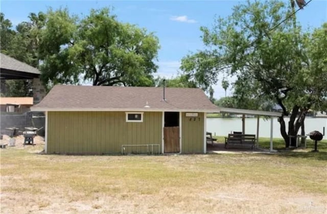 back of property featuring a storage shed and a yard