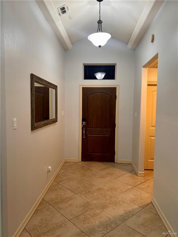 doorway featuring vaulted ceiling and light tile patterned floors